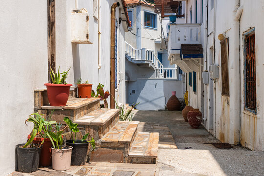 Karavostamo, Ikaria Greece small Greek fishing village street cityscape with residential home house building entrance with potted cactus plant