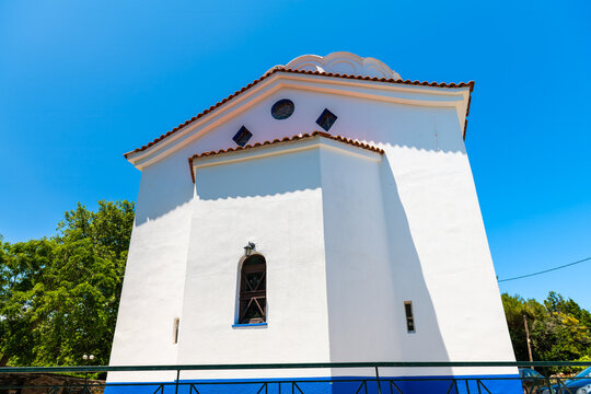 Perdiki village on Ikaria island, Greece by Saint Matrona Greek Orthodox church by street road of small town at longevity blue zone