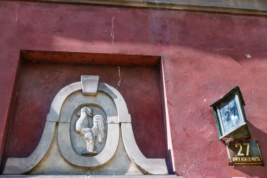 Warsaw, Poland old town market square by historic street number town architecture apartment building entrance with rooster engraving decoration