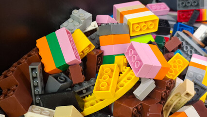 Naklejka premium Close up of various colorful Lego plastic building blocks and construction toy pieces scattered in a container on April 17, 2026 in Bangkok, Thailand