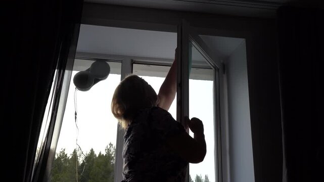 A person engages in an innovative cleaning task using a window cleaning robot, showcasing modern technology and convenience in household chores.