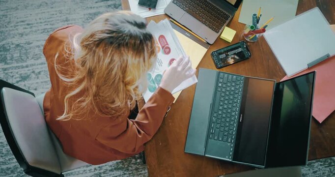 Overhead View of Woman Working with Laptops and Documents