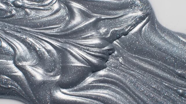 Abstract Metallic Slime Flowing and Swirling Texture Closeup.