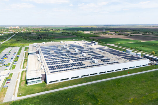 Aerial view of a modern logistics center with solar panels on the roof