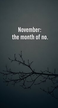November month themed text against dark background and bare branches