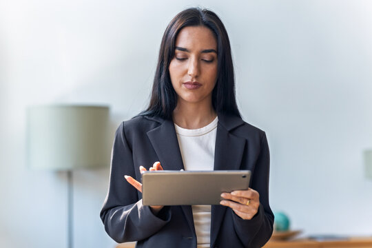 Elegant businesswoman working with digital tablet while standing in the office