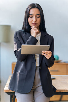 Elegant businesswoman working with digital tablet while standing in the office