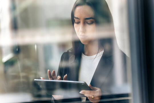 Elegant businesswoman working with digital tablet while standing in the office