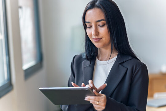 Elegant businesswoman working with digital tablet while standing in the office