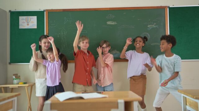 Diverse group of school children enjoying dance activity with teacher in an international classroom, encouraging active learning and teamwork