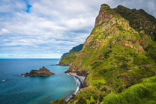 Stunning seashore view with high cliffs and green steep slopes