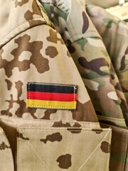 Naklejka premium German flag patch on camouflage military uniform jacket