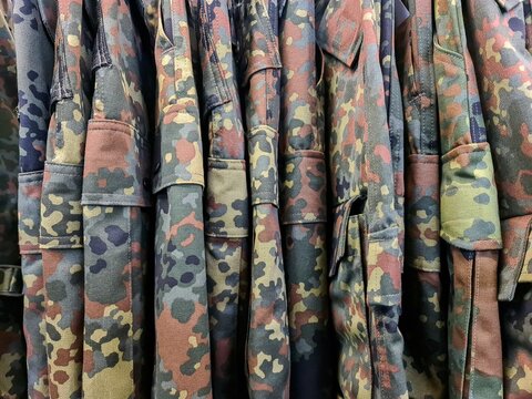 Military camouflage uniforms hanging on a rack