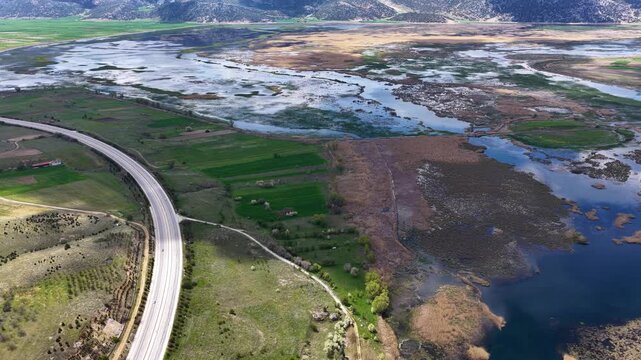 This drone footage captures the enchanting scenery of the Karakuyu Marshes, showcasing the unique harmony of winding roads, lush green farmland, and wetlands from an aesthetic perspective.