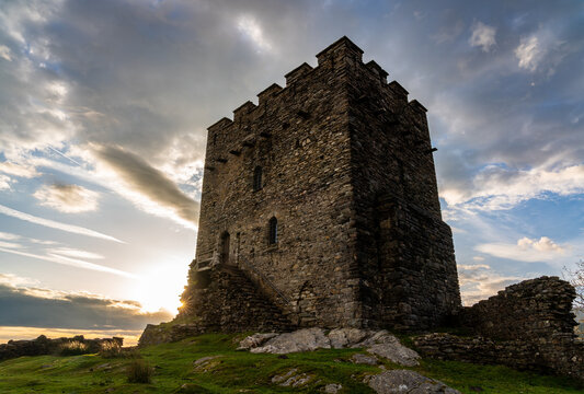 Dolwyddelan Castle tower rising from a rocky outcrop with a sunstar at dawn
