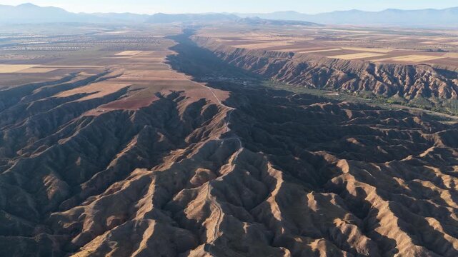 Breathtaking aerial view flying over the stunning badlands and ravines of the Gorafe desert in Granada, Andalusia, during a sunny day