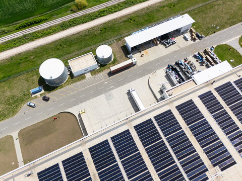 Aerial view of a modern logistics center with solar panels on the roof