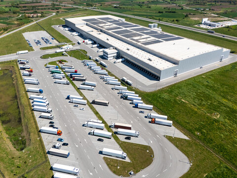 Aerial view of a modern logistics center with solar panels on the roof
