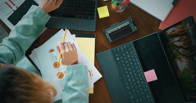 Top View of a Workspace with Laptops, Documents, and Smartphone