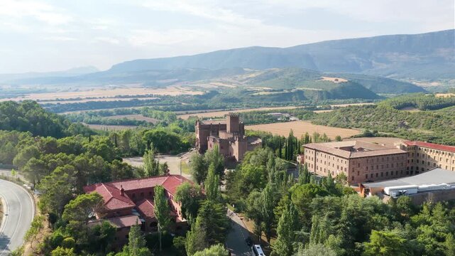 Scenic drone footage flying towards the medieval javier castle. An impressive fortress and basilica complex located in the green hills of navarre, spain