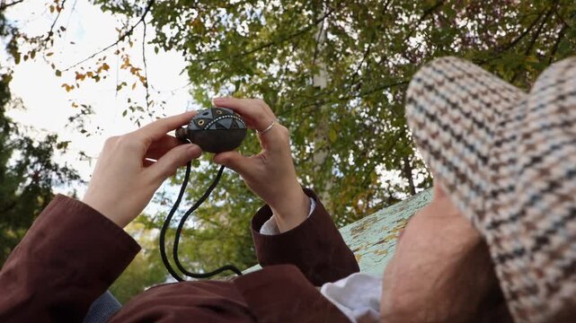 Close up of woman looking at an upturned clay whistle of ocarina, lying on bench. Bottom view. Ethnic music on a whistle toy