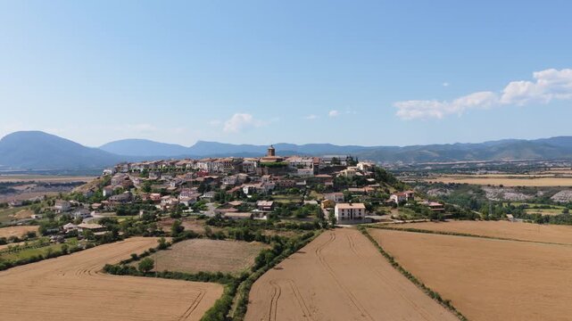 Aerial view of the medieval village of Berdun in Huesca, Spain. Beautiful cityscape on top of a hill surrounded by golden wheat fields