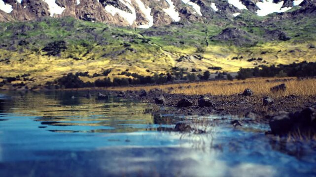 Low angle shoreline with pebble foreground, shallow rippling water and distant snowcapped peaks, intimate texture study pairing foreground detail with expansive
