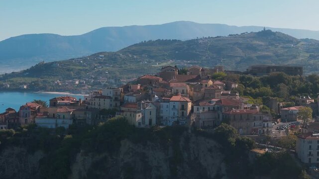 Close-up rising orbit aerial drone shot of Agropoli, Campania, Italy, showing the coastal town, harbor and historic center with detailed view of architecture and Mediterranean coastline