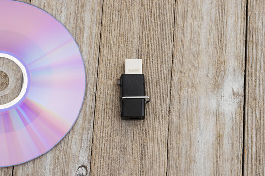 Compact disc and USB flash drive on rustic wood desk