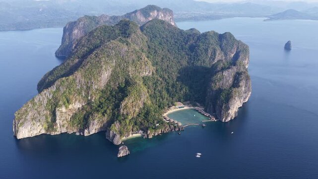 Lagen Island, a dramatic limestone island, rises in Bacuit Bay, El Nido. This area in the Philippines is a popular vacation destination due to its beautiful coral reefs, beaches, and hidden lagoons.