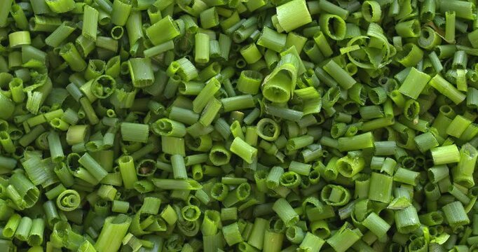 Close-up of chopped chives as a food background texture. Rotation around the right corner. 