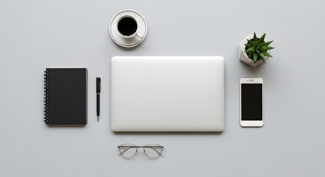 Top view of minimalist workspace with laptop notebook pen cellphone coffee and succulent on gray surface