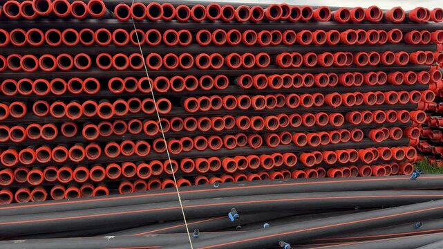 Stacked orange pipes. agricultural new pipes for watering fields, stacked on the grassHigh quality 4k footage