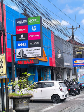 Badung, Bali, Indonesia, April 20, 2026: Laptop Store with Brand Logos and Parked Vehicles in Bali.