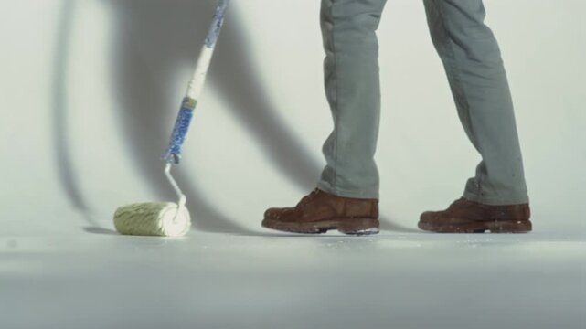 Painting work in the studio, a worker paints a cyclorama with white paint