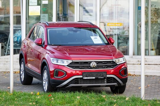 Red VW T-Roc A11 D11 crossover car in front of Volkswagen dealership