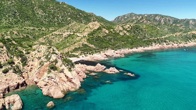 Aerial view of Su Sirboni Beach, Marina di Gairo, Sardinia, Italy. Turquoise sea, rugged red cliffs and hidden coves along the wild Ogliastra coastline
