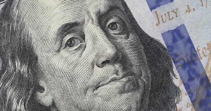 Portrait of Benjamin Franklin's face on the US 100 dollar bill. Macro footage