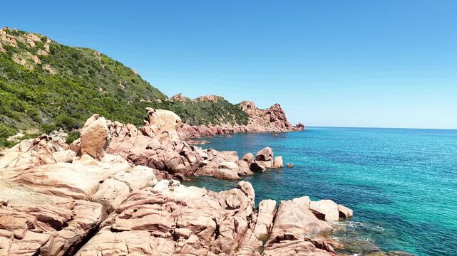 Aerial view of Su Sirboni Beach, Marina di Gairo, Sardinia, Italy. Turquoise sea, rugged red cliffs and hidden coves along the wild Ogliastra coastline