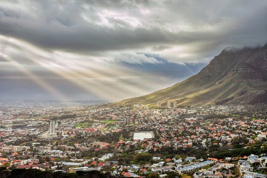 Sunlight Beams Breaking Through Dark Storm Clouds Over Cape Town Suburbs