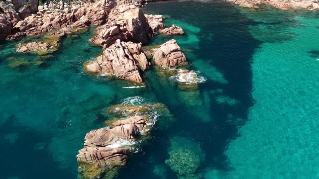 Aerial view of Su Sirboni Beach, Marina di Gairo, Sardinia, Italy. Turquoise sea, rugged red cliffs and hidden coves along the wild Ogliastra coastline