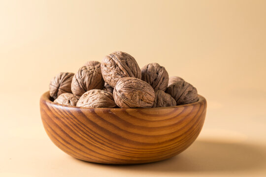 Pile of Whole Walnuts in a Wooden Bowl