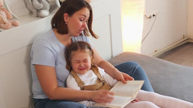 Mother and daughter practice reading together. Concept of family support in preschool education and child development. Close up, top view