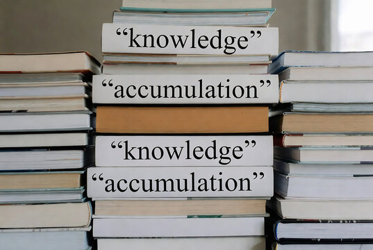 Stacked books displaying the words "knowledge" and "accumulation" repeatedly. It suggests a concept of building knowledge through repeated accumulation.