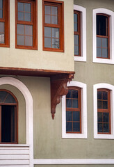 Traditional ottoman architecture facade with wooden windows. Ottoman style residential building featuring traditional wooden framed windows, decorative corbels and green plaster walls. © ismailgazel