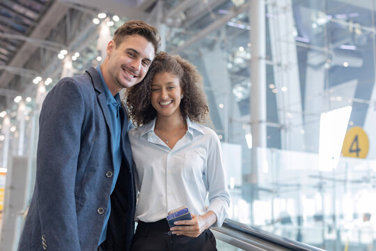 Couple shares a moment at an airport while waiting to board their flight together