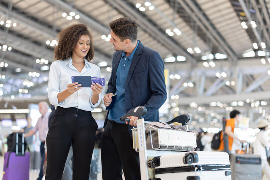 Couple checks travel details on their ticket at the airport before their flight