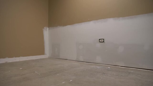 Drywall repair and patching from sump pump failure, An empty basement room with concrete floor