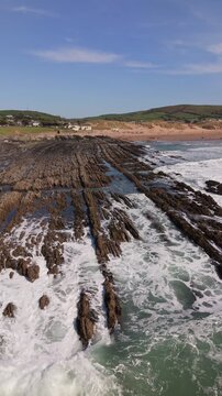 Aerial drone footage of Croyde Beach in North Devon, England, showcasing a sandy shoreline, rolling waves, and a popular surfing destination along the Atlantic coast