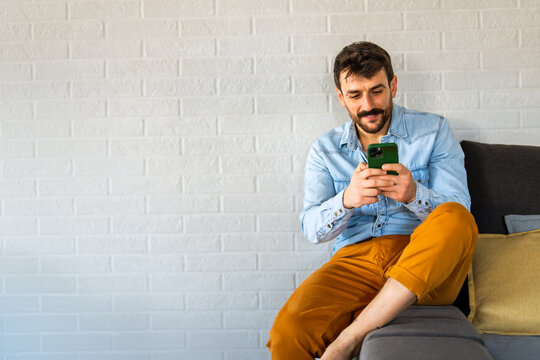 Young man using cellphone for work, social media or relaxation. Smart phone people concept.